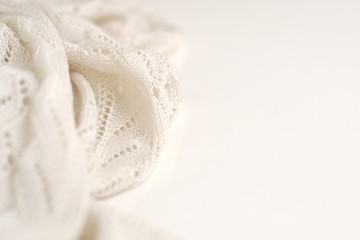 Ivory color crochet sweater on white background. Texture detail close up.