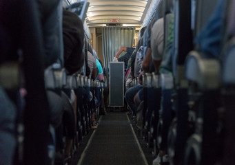 Blurred photo of the aircraft interior. Passengers in the cabin airplane