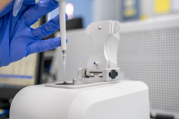 The researcher drops 2 micro-liters of the sample on pedestal to measures the RNA concentration and...