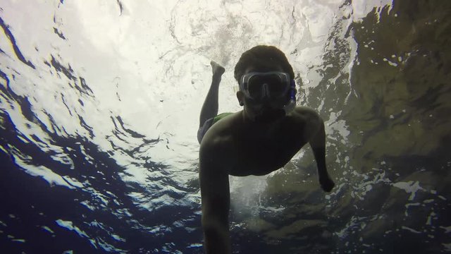 Man Swimming Underwater In Tropical Blue Ocean