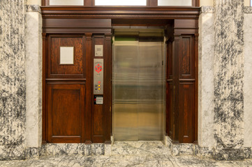 Old elevator with metal doors and wood grain paneling © davidrh