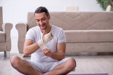 Hand injured man doing exercises at home