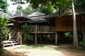 Traditional Thai house made from wood with trees around the house