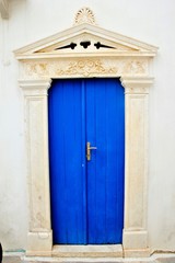  Blue door with marble decoration in Pyrgos village, Tinos island, Cyclades, Greece.