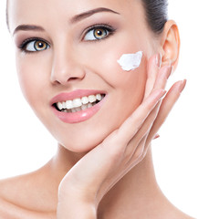 Smiling woman with cosmetic  cream on a clean fresh face