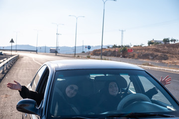 Fototapeta na wymiar Happy arabic waving of happiness while driving a car