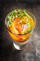 Gin based cocktail with peaches and thyme. Selective focus. Shallow depth of field.