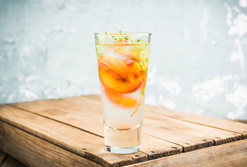 Gin based cocktail with peaches and thyme. Selective focus. Shallow depth of field.