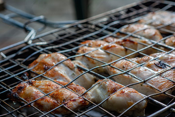 Cooked and fried pieces of chicken on a grill