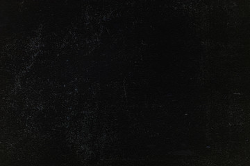 Dark concrete wall texture with small cracks carelessly painted with black paint