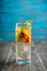 Gin based cocktail with peaches and thyme. Selective focus. Shallow depth of field.