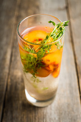 Gin based cocktail with peaches and thyme. Selective focus. Shallow depth of field.