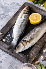 Fresh branzino fish with parsley, lemon and pink Himalayan salt