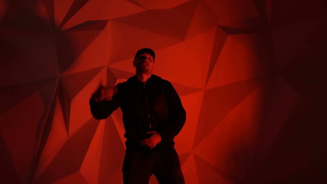 Rapper guy rap in front of the camera on a red background