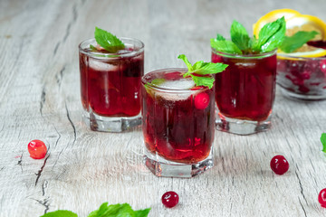 Red stemware shot alcoholic cold cocktail with cranberries raspberries lemon and mint. Selective focus, copy space.