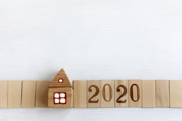 model of a wooden house with a long fence. real estate with a plot of 2020