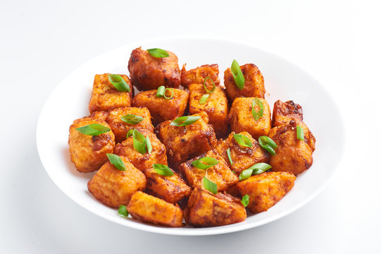 Paneer Manchurian or Paneer 65 isolated on white background. Paneer Manchurian is Indian Chinese cuisine dish with panner cheese, tomatoes, onion, soy sauce.
