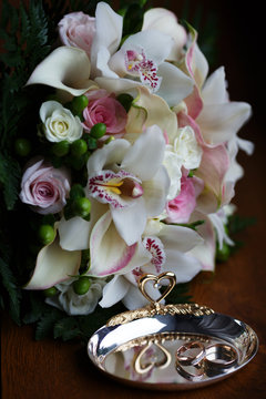 Wedding still life of rings and bride's bouquet.