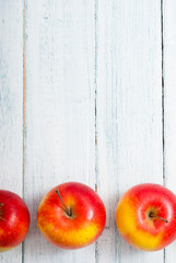 apple fruits in a row, white wooden table background