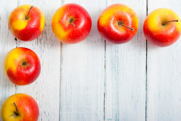 apple fruits in a row, white wooden table background