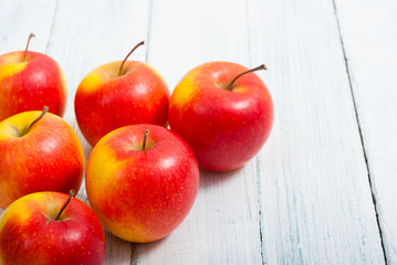 apple fruits in a row, white wooden table background
