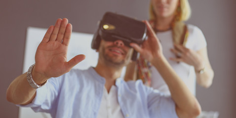 Young male software programmer testing a new app with 3d virtual reality glasses in office.