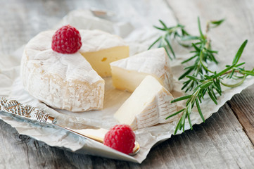 Gourmet spicy Camembert cheese, brie on white paper background with cheese knife. Spicy appetizer for gourmets. Selective focus