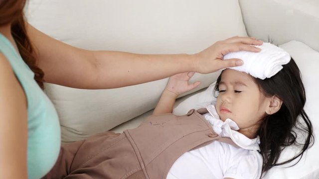 Asian kid girl are getting sick from the flu Causing the body to have a high temperature Must be maintained Such as wiping the body to improve the body And hurry to consult a professional doctor