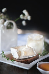 Traditional French goat milk cheese Saint-Maure-de-Touraine on a piece of delicate farm bread . Russian farm products. Close up. Selective focus