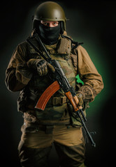 Fototapeta premium a man in uniform with a gun posing, aiming, reloading, shooting, on a dark background in the Studio