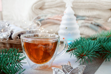 Transparent double bottom glass Cup with hot drink on table with Christmas decor. Warming drink in...