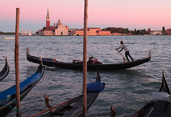 Fototapeta na wymiar Gondoliere al Bacino di San Marco davanti all'isola di San Giorgio Maggiore