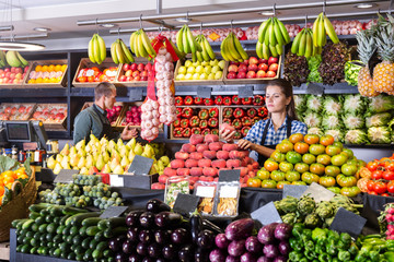 Shop assistants working in fruit and vegetable shop - obrazy, fototapety, plakaty