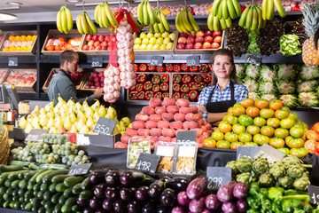 Posing fine woman and working man in fruit shop