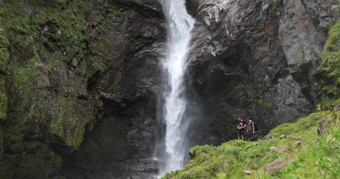2 travelers scouting the best location for a photoshoot near a waterfall in Switzerland.