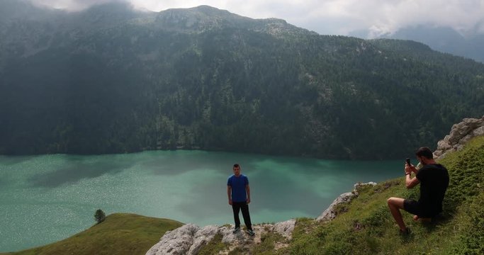 Young travellers take a photo with the stunning background of Ritom Lake in the Swiss Alps