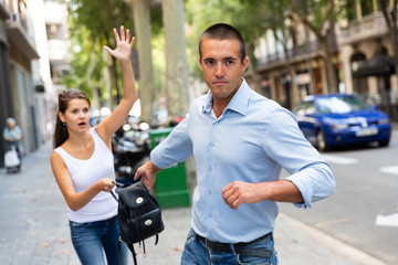 Bandit man is stole the handbag from emotional female