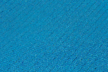Naklejka na ściany i meble Water ripples on blue tiled swimming pool background. View from above.