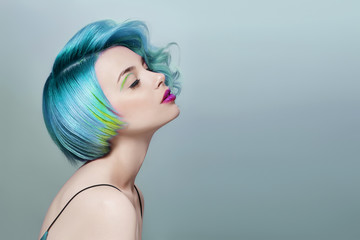 Portrait of a woman with bright colored flying hair, all shades of blue purple. Hair coloring,...