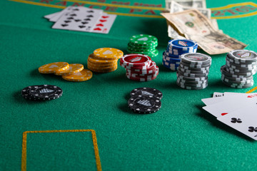 Casino, night life, online gambling business games. Chips, cards and dollars on a green table.