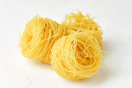 raw pasta capellini isolated on white background