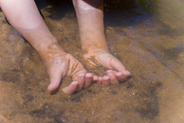 Asian Children playing  barefoot in stream water, play mud and sand.