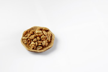 wood plate of salted peanuts isolated on white background. snack to beer