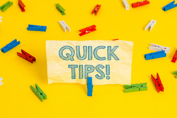 Writing note showing Quick Tips. Business concept for small but particularly useful piece of practical advice Colored clothespin papers empty reminder yellow floor background office