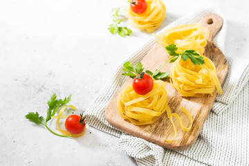 Raw homemade pasta tagliatelle on a wooden Board. Italian cuisine