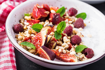 Chia seed pudding made with raspberries,  figs and mint on dark background.  The concept of good nutrition.