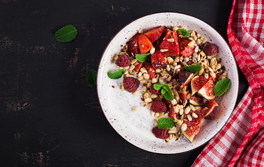 Chia seed pudding made with raspberries,  figs and mint on dark background.  The concept of good nutrition. Top view