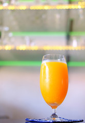 glass of orange juice on background of blue sky