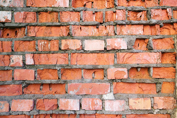 Wall of red broken bricks, background and texture