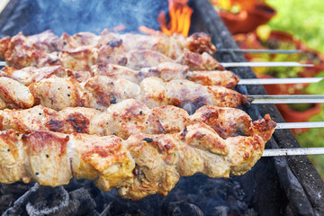 Marinated shashlik preparing on a barbecue grill over charcoa